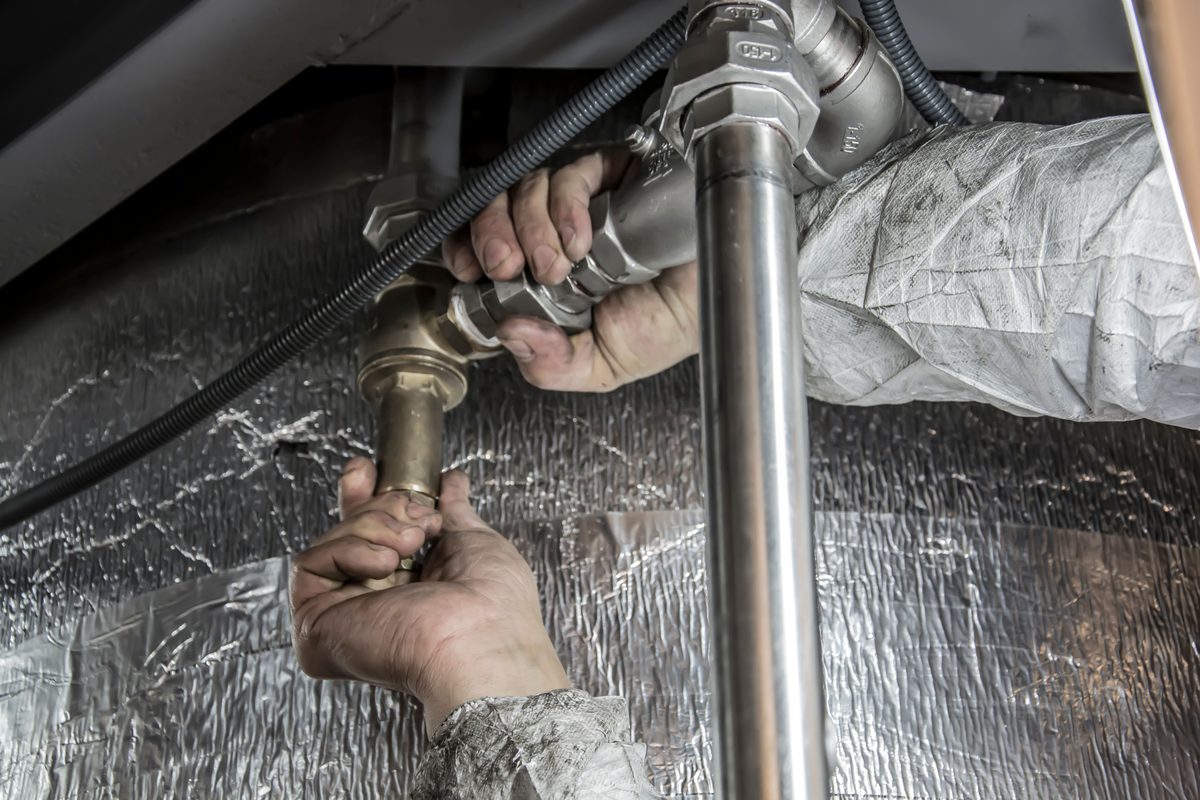 Installateur behebt eine Verstopfung unter dem Waschbecken